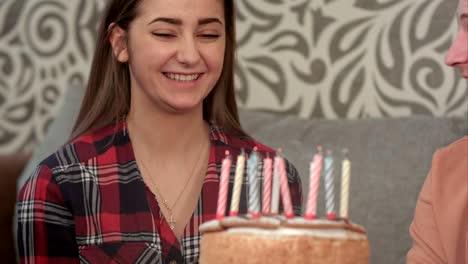 Glückliches-Mädchen-an-ihrem-Geburtstag-macht-einen-Wunsch-und-bläst-die-Kerzen-auf-dem-Kuchen