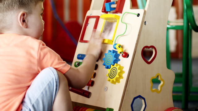 A-little-boy-in-a-kindergarten-plays-a-developing-toy