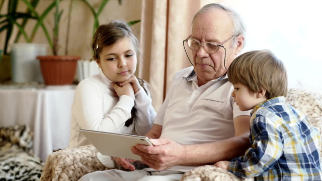 Grandfather-using-digital-tablet-with-grandchildren