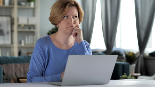 Mujer-Senior-viejo-pensativa-pensando-y-trabajando-en-ordenador-portátil