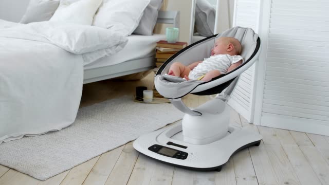Bebé-duerme-en-una-silla-mecedora-para-niños-diseño-de-alta-tecnología-en-dormitorio-blanco