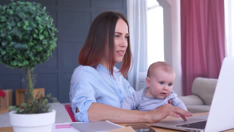 Feliz-madre-con-la-niña-mientras-trabajaba-en-su-casa