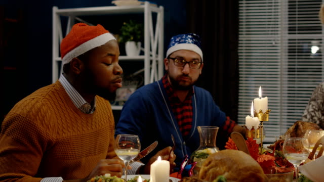 Diverse-Freunde-Speisen-gemeinsam-zu-Weihnachten