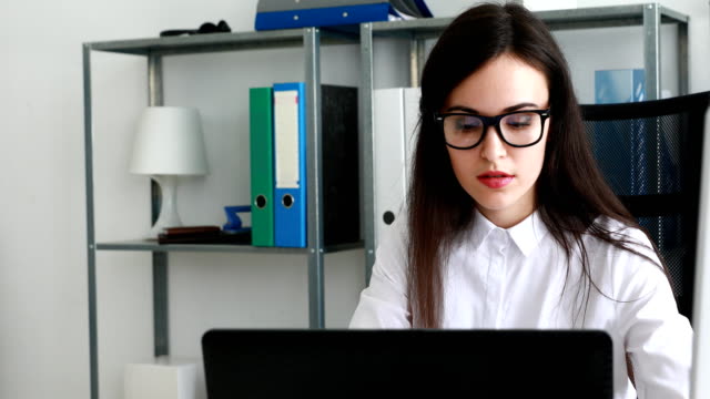 businesswoman-taking-off-black-glasses-and-propping-head-with-hand-in-modern-office