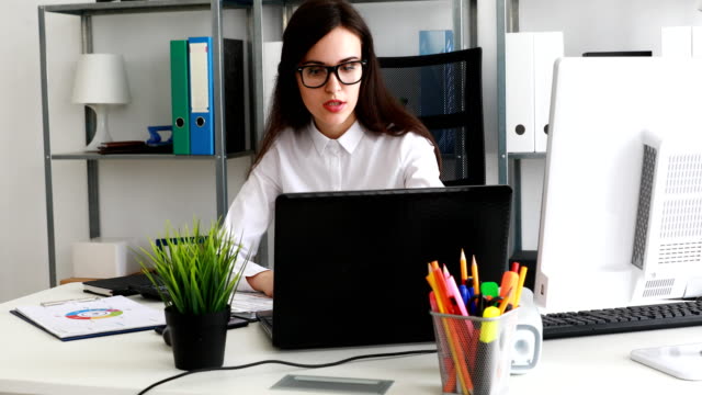 geschäftsfrau-in-schwarze-Brillen-arbeiten-am-Laptop-im-modernen-Büro