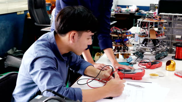 Männliche-Ingenieur-Ausbildung-zum-Arbeiten-mit-Robotik-Prototyp-in-Werkstatt.-Menschen-mit-Wissenschaft,-Technologie,-Bildungskonzept.