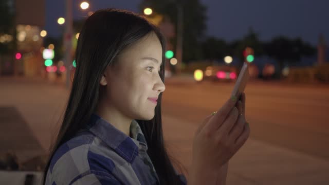Junge-Asiatin-mit-Tablet-in-den-Straßen-der-Stadt