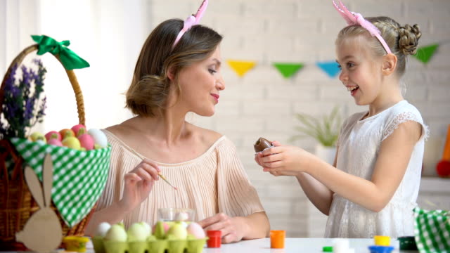 Niña-con-huevo-de-chocolate-madre,-crianza-adecuada,-Pascua-viene