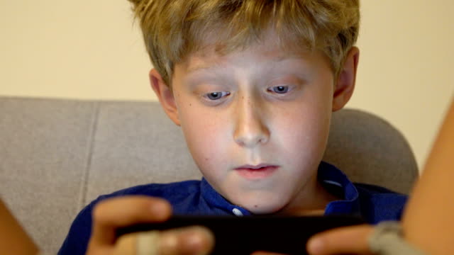 Kleiner-Junge-das-Online-Spiel-mit-der-mobile-Smartphone-Gadget-Gerät-4K-Filmmaterial