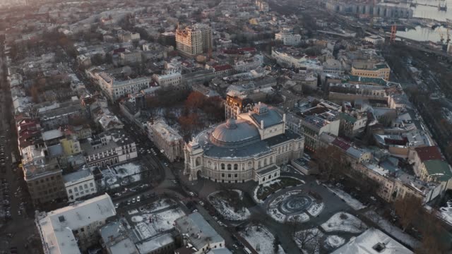 Vista-aérea-en-el-teatro-de-ópera-y-ballet-de-Odessa-durante-el-invierno-en-puesta-de-sol,-tiro-de-seguimiento
