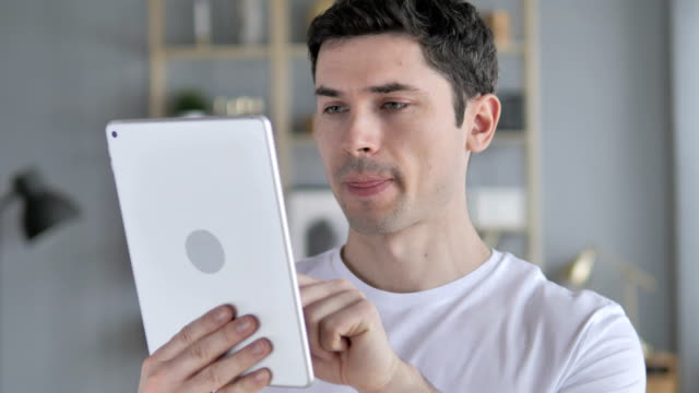 Young-Man-Using-Tablet-at-Workplace