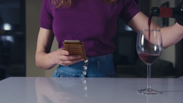 Frau-mit-Smartphone-gießt-Wein