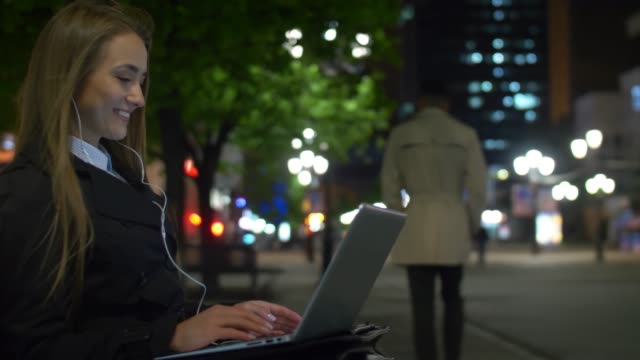Geschäftsfrau-Videoanrufe-auf-Laptop-im-Freien-am-Abend