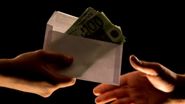 Hand-giving-euros-in-envelope-isolated-on-black,-corruption-or-illegal-salary