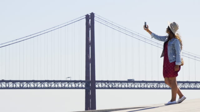 Junges-Mädchen-nimmt-Selfie-auf-dem-Hintergrund-berühmte-Brücke