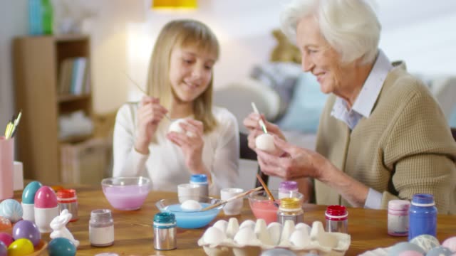 Grandmother-and-Granddaughter-Painting-Eggs-and-Smiling
