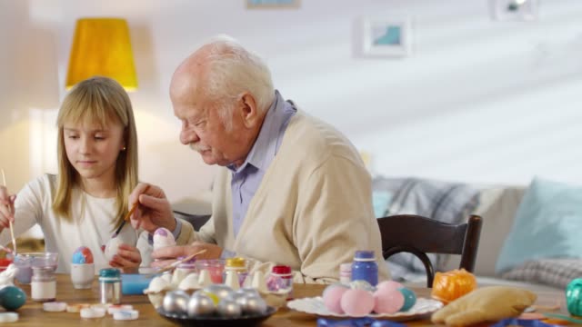 Retrato-de-chica-y-abuelo-pintando-huevos
