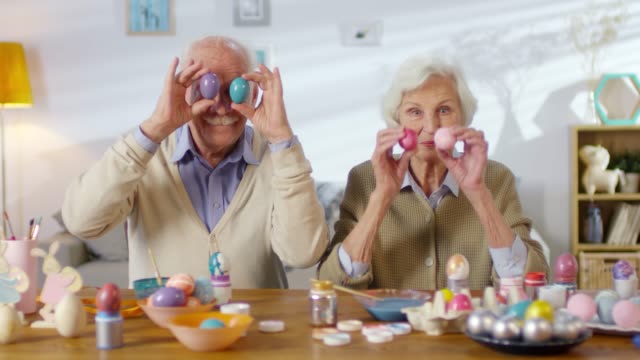 Elderly-Couple-Holding-Eggs-over-Eyes