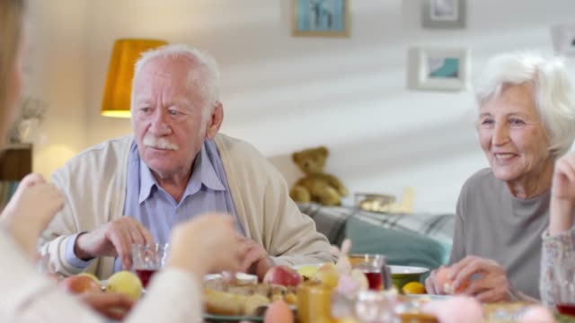 Großeltern-schmunzeln-und-zu-Ostern-mit-dem-Enkelkind-reden