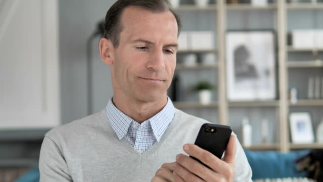Portrait-of-Middle-Aged-Man-Busy-Using-Smartphone
