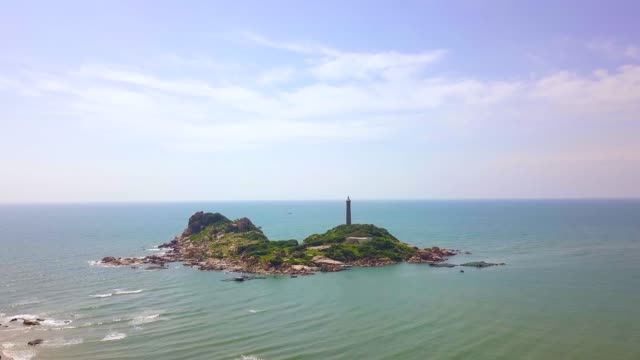 Aerial-view-lighthouse-on-rocky-island-in-blue-sea-landscape.-Drone-view-light-house-on-cliff-in-ocean-on-blue-sky-background