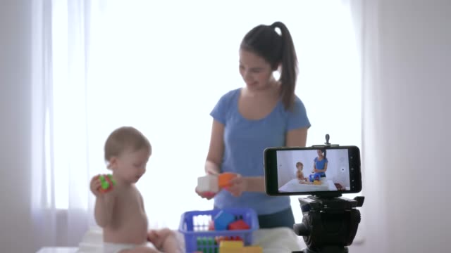 blogging,-nice-child-boy-with-girl-played-by-educational-toys-and-recording-live-tutorial-video-on-mobile-phone-for-followers-in-social-networks