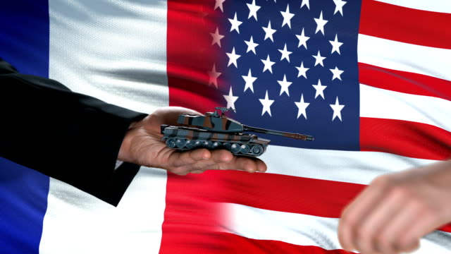 France-and-USA-officials-exchanging-tank-for-money,-flag-background,-agreement