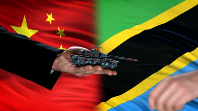 China-and-Tanzania-officials-exchanging-tank-money,-flag-background,-partnership