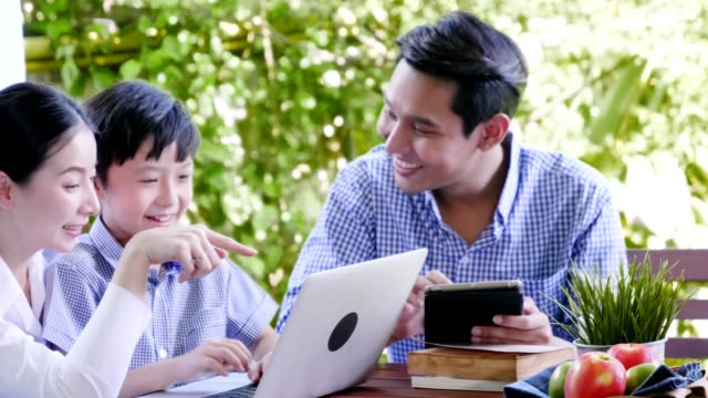 Familie-mit-Laptop-und-digitale-Tablet-Arbeit,-Eltern-lehren-ihren-Jungen-versuchen,-auf-Labtop-zu-lernen