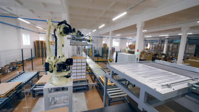 Robotic-tool-is-displacing-carton-packages.-Modern-factory-equipment.
