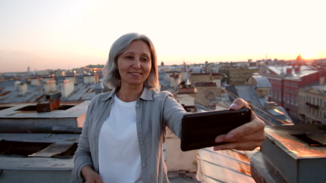 Grey-haired-Female-Tourist-Making-Selfie-on-Roof