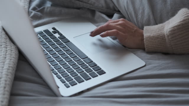 Frau-mit-Laptop,-während-sie-im-Bett-ruht