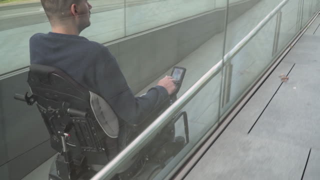 4k-resolution-follow-of-a-man-on-electric-wheelchair-using-a-ramp.-Accessibility-concept