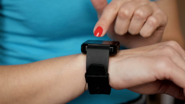 Frau-mit-ihrem-Smartwatch-Touchscreen-tragbare-Technologie-Gerät.-Mädchen-machen-Gesten-auf-einem-tragbaren-Smart-Watch-Computer-Gerät,-Nahaufnahme.
