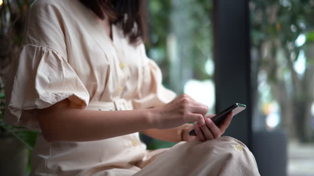 Joven-mujer-asiática-usando-el-teléfono-inteligente