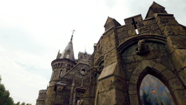 stone-sculptures-on-facade-of-fortress,-stained-windows,-gothic-style,-camera-is-moving