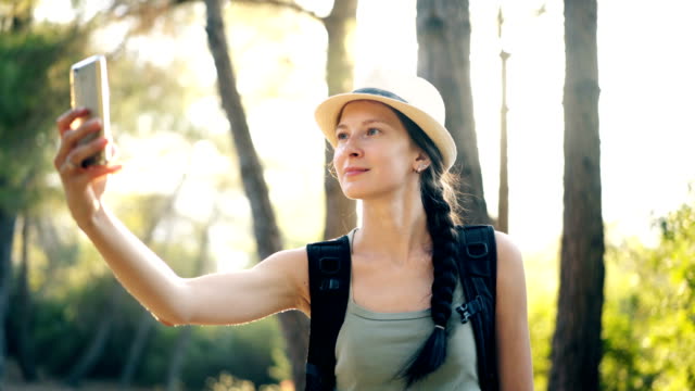 Lustige-touristischen-Mädchen-mit-Hut-Selfie-fotografieren-mit-Smartphone-Kamera-während-Reisen-und-Trampen