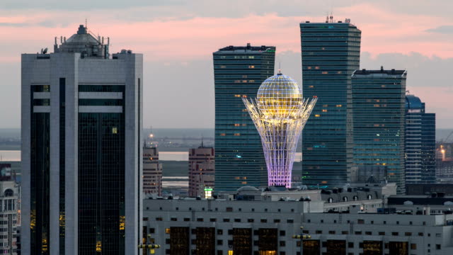 Erhöhte-Blick-bei-Nacht-auf-das-Stadtzentrum-und-das-zentrale-Geschäftsviertel-mit-gelben-Türme-Zeitraffer,-Kasachstan,-Astana