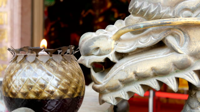 Ursprüngliche-Kerze-im-chinesischen-Stil.-Bronzestatue-von-einem-Drachen-und-einer-brennenden-Kerze-in-der-Nähe