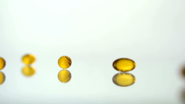 Medical-pills-scatter-on-a-white-background.Yellow-pills.-Slow-motion.-Pills-background