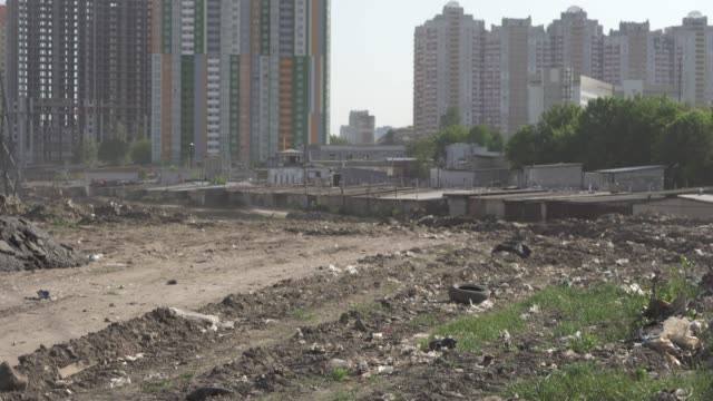 Outskirts.-Polluted-soil-with-various-debris-near-the-metropolis-with-high-rise-buildings.-Environmental-pollution