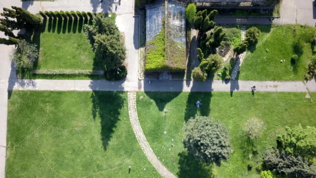 Aerial-panoramic-video-shooting-from-the-drone-above-the-central-zone-of-greenhouses-and-gardens-of-the-National-Exhibition-Center-in-Kiev,-Ukraine.-Dolly-out-motion.-FullHD
