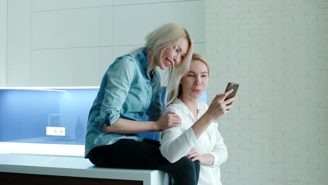 Dos-mujeres-viendo-fotos-en-el-smartphone