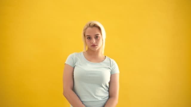 Attraktive-blonde-junge-kaukasischen-plus--Size-Model-schauen-in-die-Kamera-gelben-Hintergrund