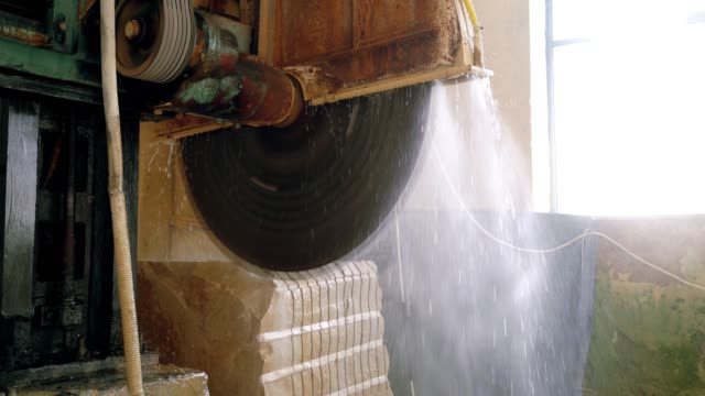 an-automatic-equipment-with-water-dispenser-is-cutting-a-huge-stone-with-a-steel-disc.