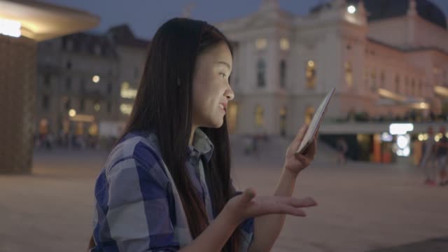 Schöne-junge-Frau-im-Gespräch-mit-ihren-Freunden-mit-tragbaren-Tablet-Gerät