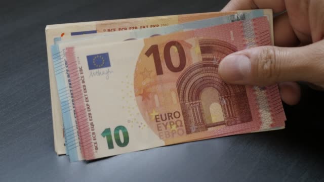 Taking-from-table-by-hand-European-Union-currency-lot-4K-3840X2160-UltraHD-video---Wad-of-Euro-money-paper-banknotes-taking-4K-2160p-30fps-UHD-slow-tilt-footage