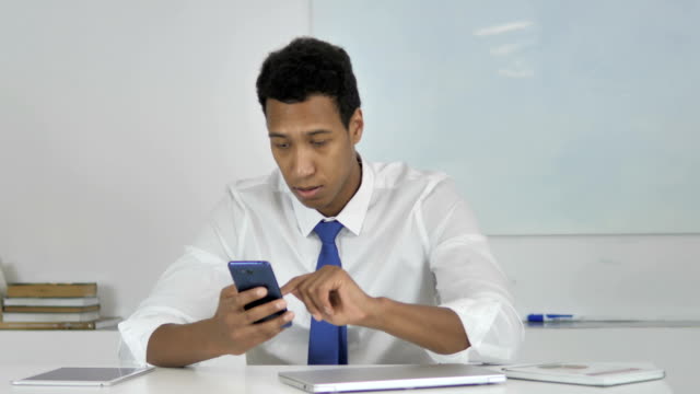 Afro-American-Businessman-Excited-for-Success-while-Using-Smartphone
