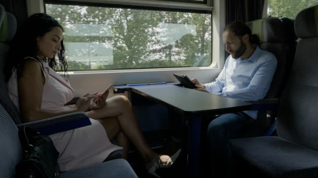 Mujer-y-hombre-viajando-en-tren-siendo-no-comunicativo-usando-sus-smartphones-para-pasar-tiempo-adicto-a-las-redes-sociales-en-línea