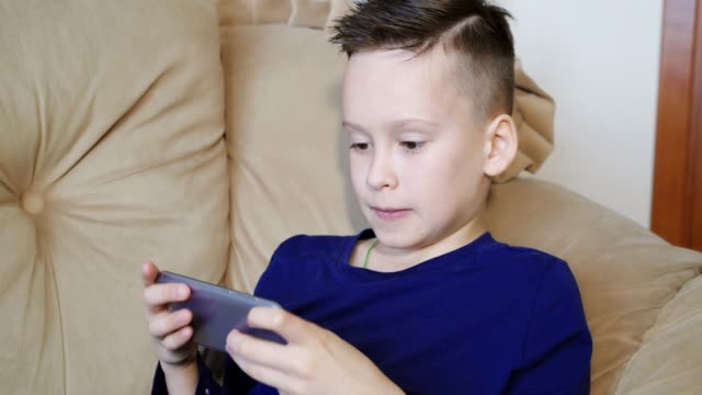 Good-kid-is-playing-on-his-smartphone-and-becoming-nervous-when-loses.